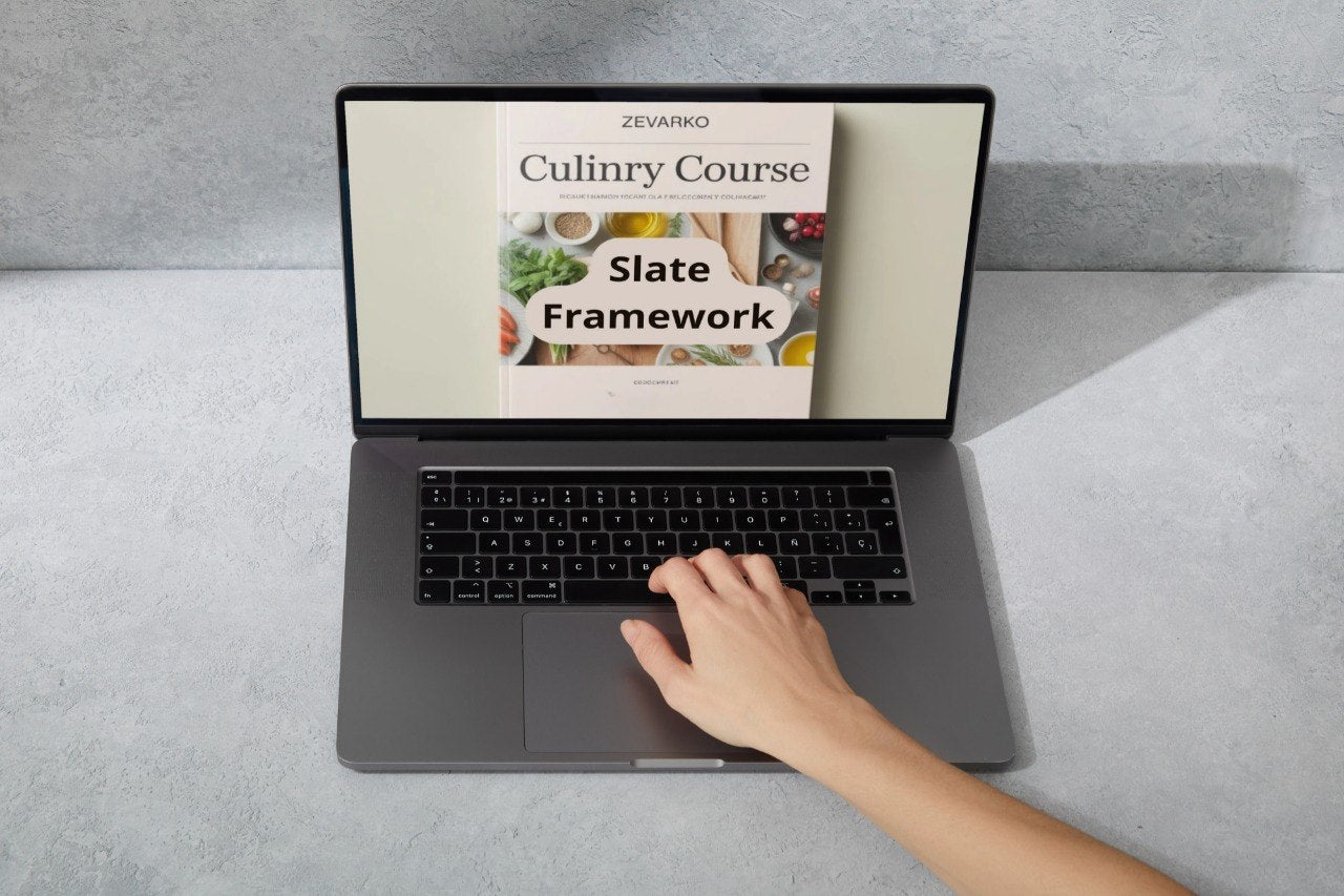 Laptop displaying a culinary course on a gray surface with a hand interacting with it.